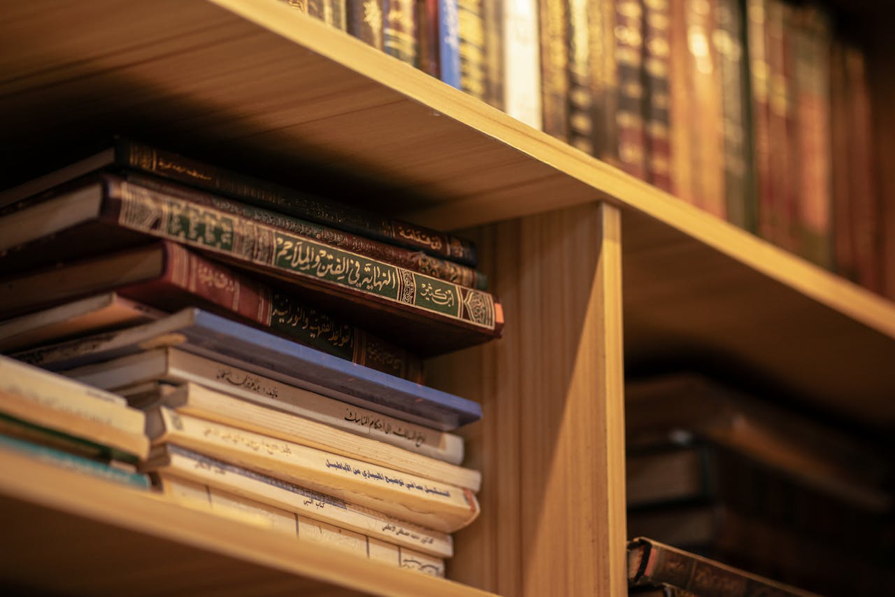 digital A stack of Islamic religious books on a wooden shelf, highlighting Arabic scripts and cultural significance.